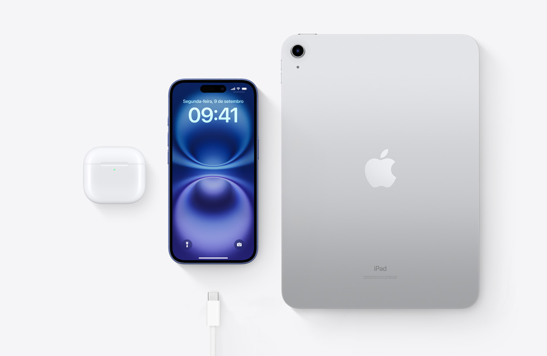 Imagem aérea dos AirPods Pro, do iPhone 16 e de um iPad com conector USB-C para demonstrar como os três aparelhos podem ser recarregados com o mesmo cabo USB-C.