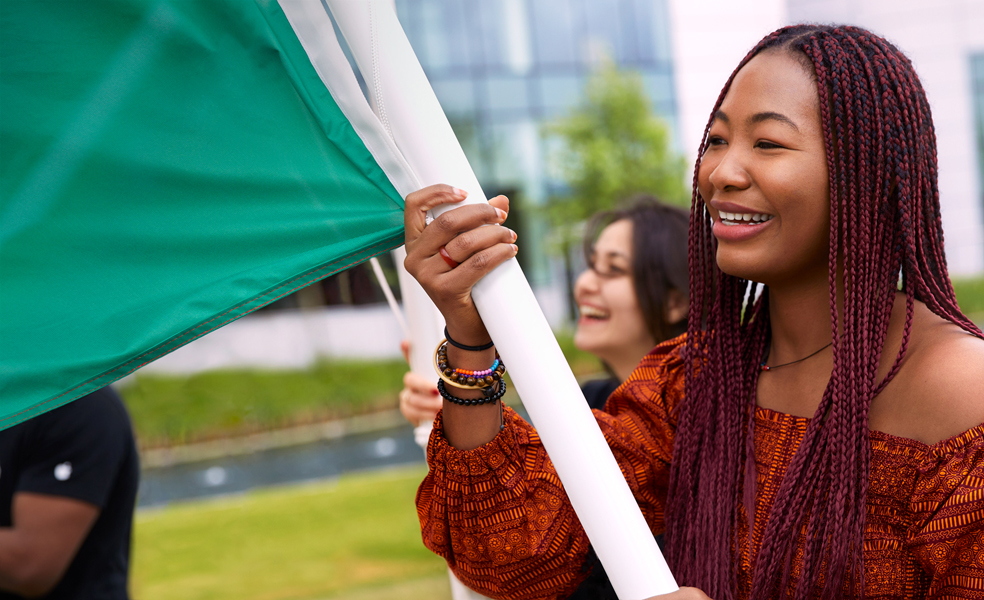 Apple Cork employee walking and holding a flag.