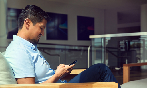 Edgar schaut sitzend auf sein Handy.