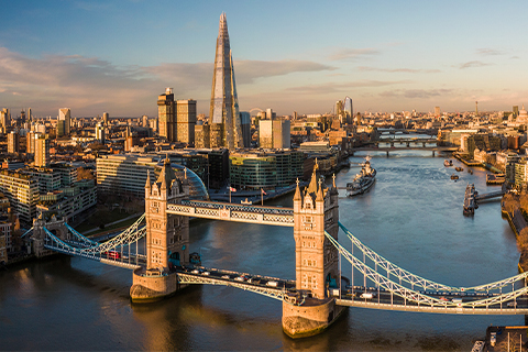 Aerial view looking over London and the River Thames, with Tower Bridge in the foreground.