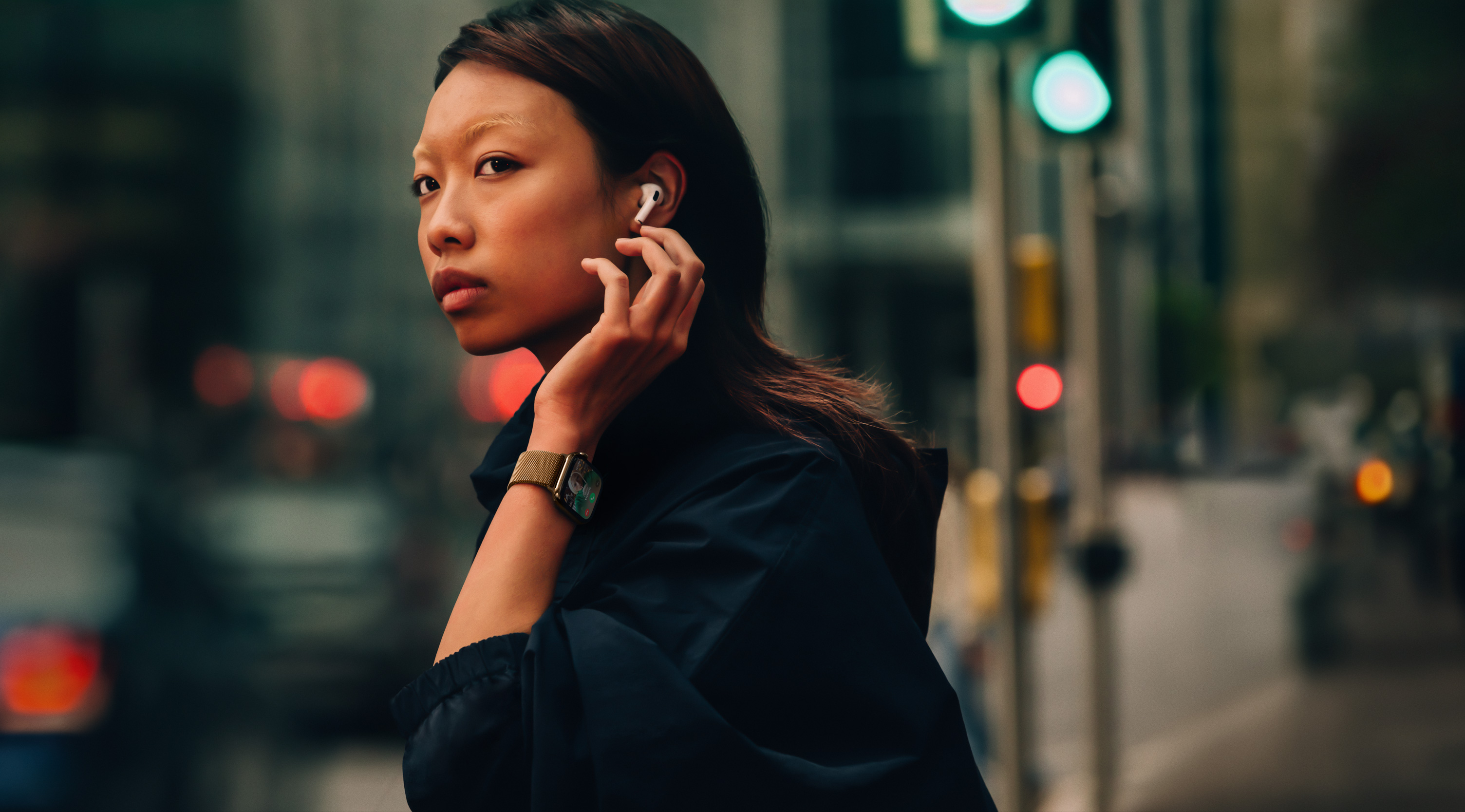 Una mujer que camina por la calle lleva puestos un Apple Watch Series 10 y unos AirPods.