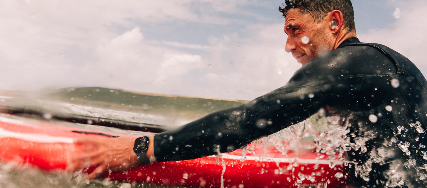 A man with a paddle board in the water wearing Apple Watch Series 10.