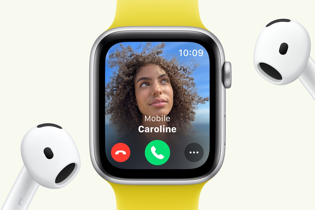 На Apple Watch SE відображається вхідний виклик, поруч розташовані навушники AirPods