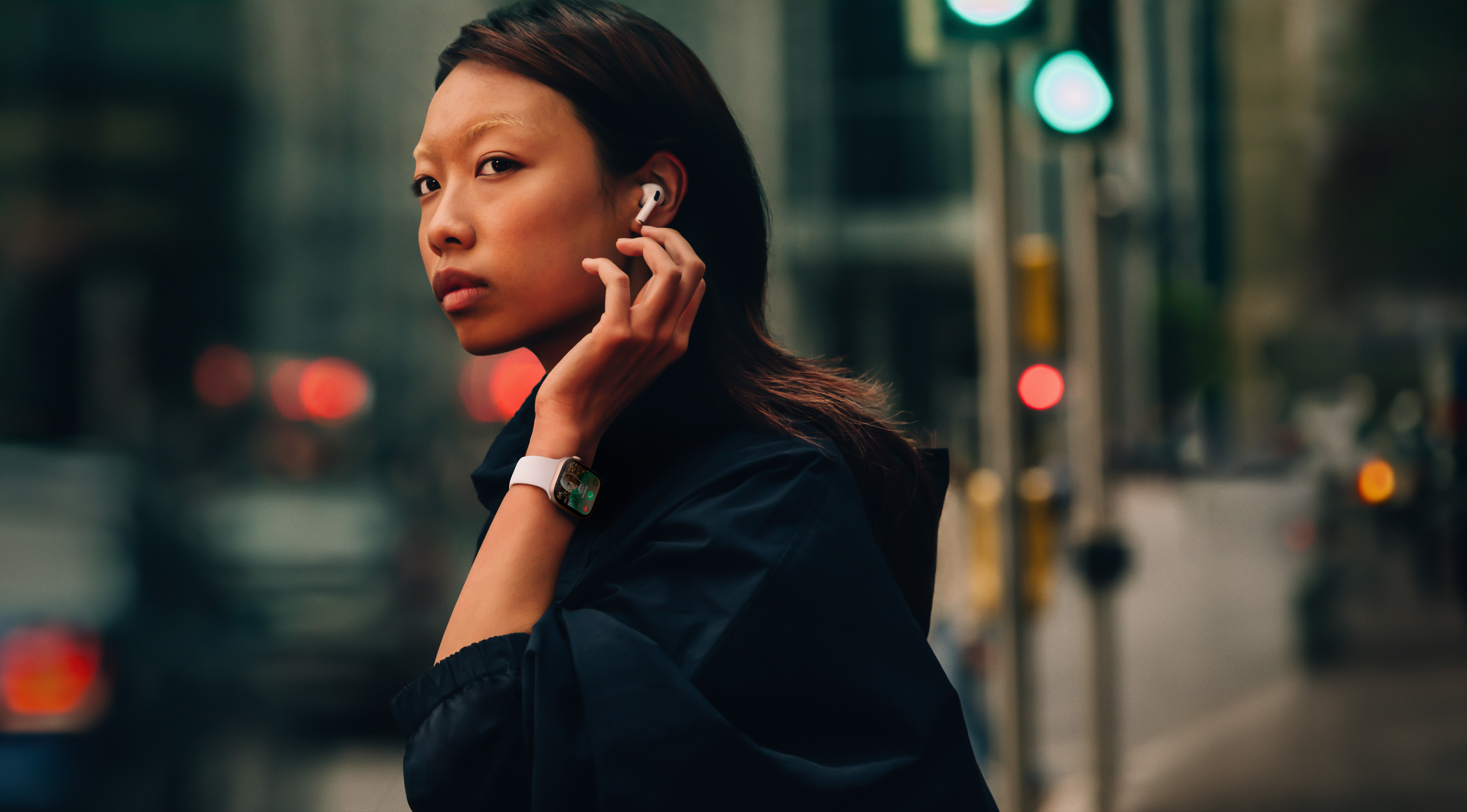 Жінка на вулиці з Apple Watch Series 10 та AirPods.