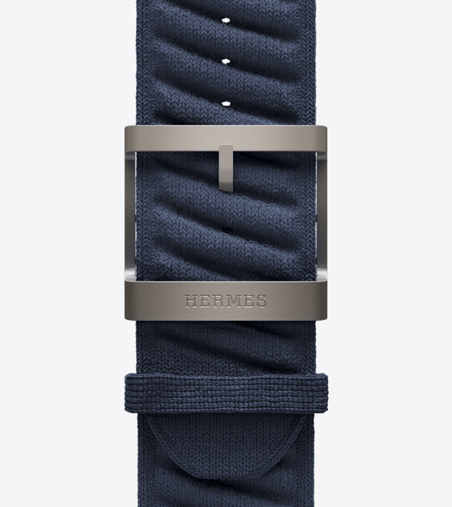 Close-up view of the new textured knit En Mer band in Bleu Nuit (blue) with a titanium buckle.