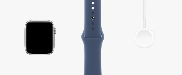 Van links naar rechts: vooraanzicht van de kast van Apple Watch SE, een sterrenlicht sportbandje en een magnetische oplader-naar-USB‑C-kabel.