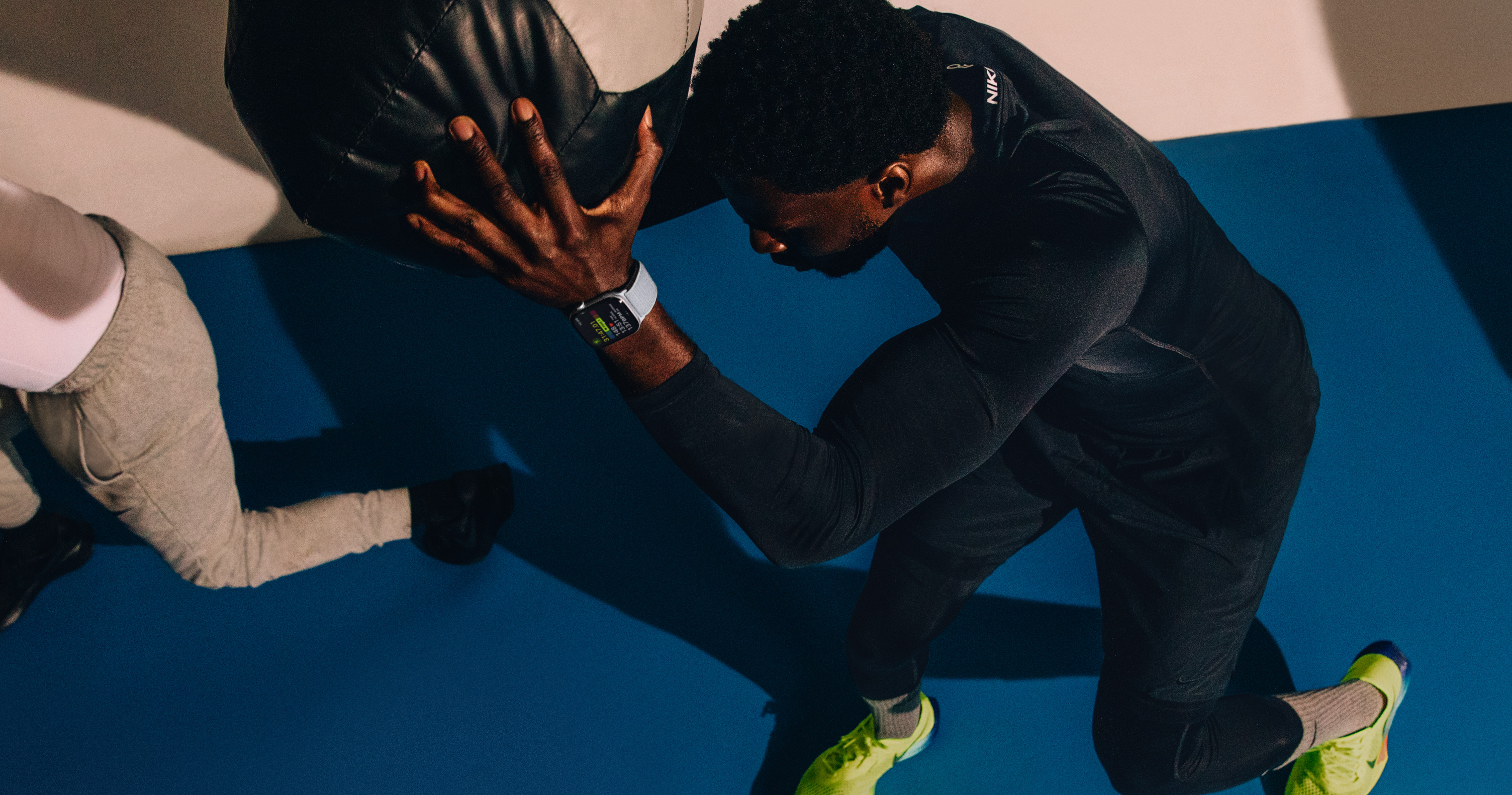 A man working out with a medicine ball while wearing Apple Watch Series 10.