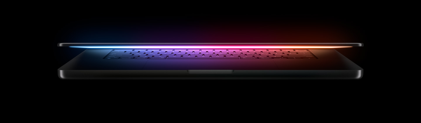 Une lueur multicolore émane de l’écran d’un MacBook Pro entrouvert et en éclaire le clavier